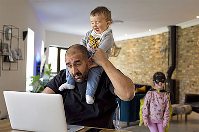 Mann mit Kindern vorm Laptop