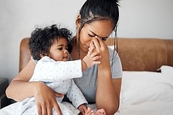 Überforderte Mutter mit Kleinkind