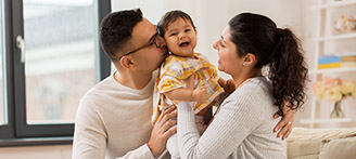 Mutter und Vater sitzen mit Baby auf Sofa