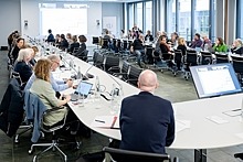 Großer Konferenztisch mit Teilnehmenden